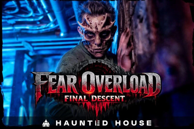 fear-overload-final-descent-attraction A horrifying figure with a mutated, bone-exposed face and a green jumpsuit stares menacingly in a dark, blue-lit industrial corridor. The text reads "Fear Overload: Final Descent"